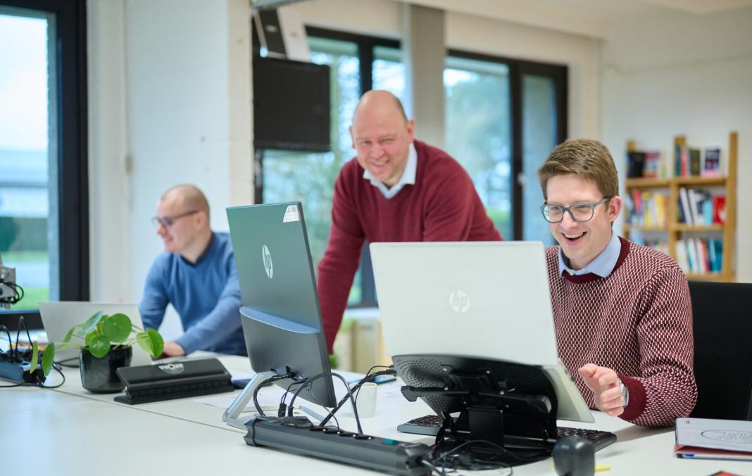Collega\'s mact bij computerschermen