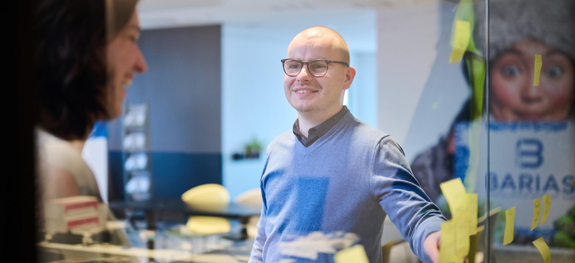 Mact workflow op kantoor: man praat tegen vrouw